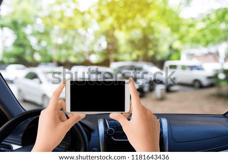 woman use mobile phone in the car with blurred image of the outdoor car park 
