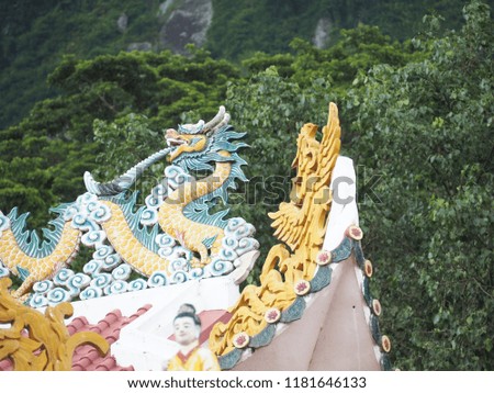 Dragon decoration on top of Buddhist temple in Vietnamese jungle