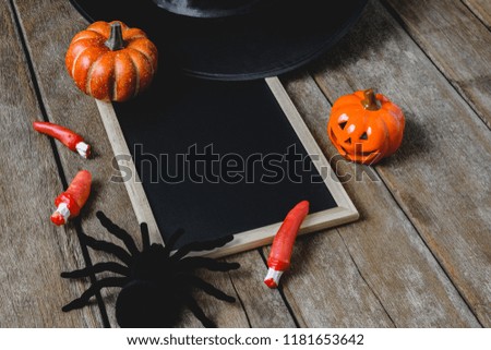halloween background with Pumpkins, Witch hat, Black spider and empty chalkboard on wooden floor. view from above