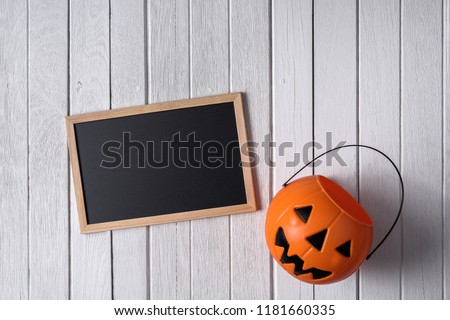 halloween background with Pumpkins and empty chalkboard on white wooden floor. Top view