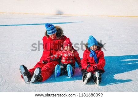 father with little son and daugther skating in winter