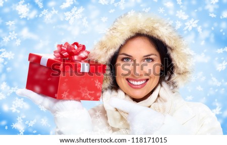 Beautiful christmas girl with gift. Over winter background.