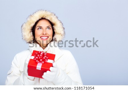 Beautiful christmas girl with gift. Over winter background.