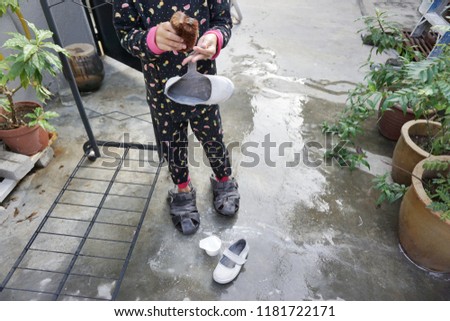 Picture of washing dirty white shoes with brush and  a cup of soap.School and cleaning concept.
