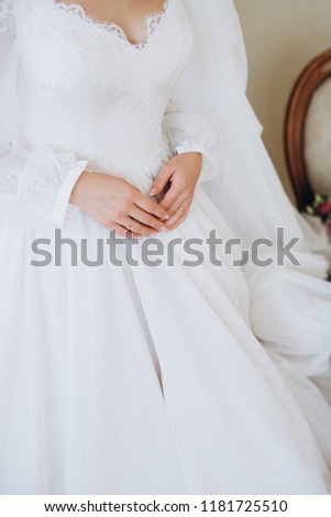 Gentle hands of the bride on the dress. Morning of the bride.