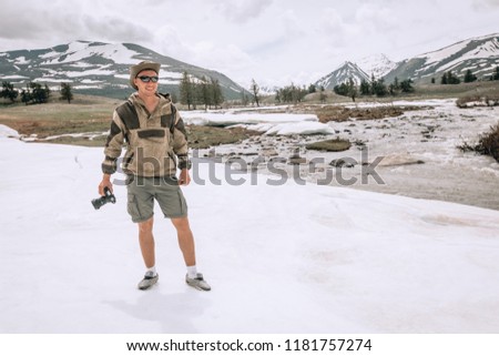 young man taking pictures in winter snow field park Tourist. in Mongolia snow landscape, spring 