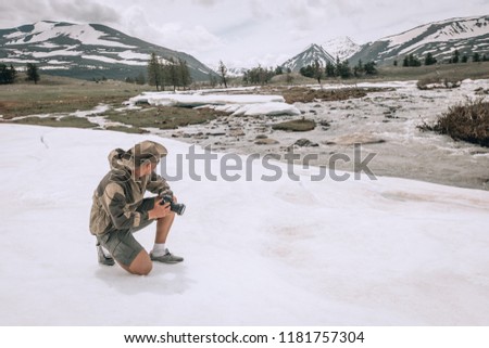 young man taking pictures in winter snow field park Tourist. in Mongolia snow landscape, spring 