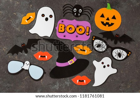 on a dark background symbols of the holiday of the Halloween: pumpkin, bats, ghost, hat, spider, lips with the vampire teeth