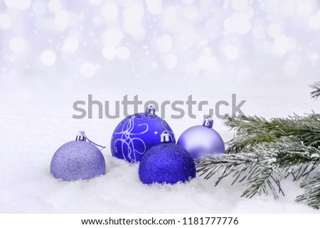 Christmas ornaments lying in the snow on a glade.