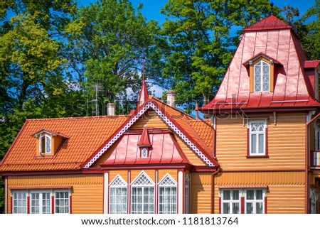 Beautiful summer house next to the forest. Wooden cottage with small towers and decorative elements. Concept of luxury lifestyle and architectural masterpiece. 
