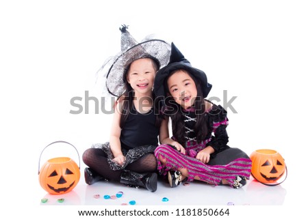 Asian children wearing halloween costume sitting on the floor over white background