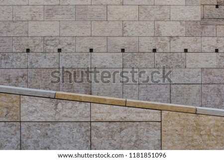 Symmetrical horizontal vertical angled lines of stone tiles of modern architecture facade of public building