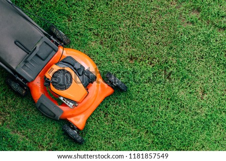 Lawn mowers cut grass. Garden work concept background Royalty-Free Stock Photo #1181857549