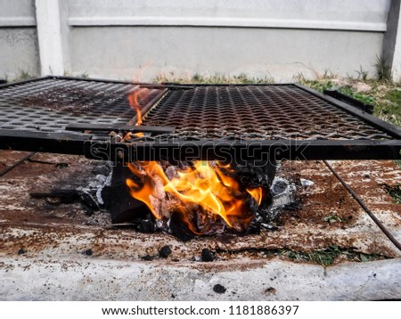 
Rustic grill with burning coal. Small flames