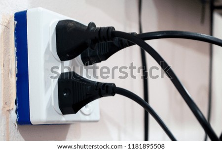 Electric wire with plug near outlet, Electrical outlet with power cord.