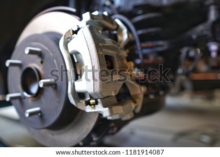 Selective focus of Brake Disc of the vehicle for repair.Automobile mechanic in process of new tire replacement.Car brake repairing in garage.Car Service and technician concept. Royalty-Free Stock Photo #1181914087