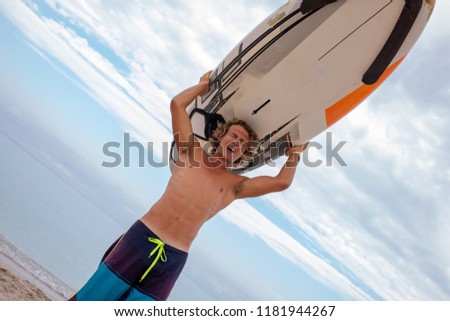 Handsome man walk with white blank surfing board wait for wave to surf spot at sea ocean shore. Concept of sport, fitness, freedom, happiness, new modern life, hipster.