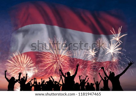 Happy people are looking holiday fireworks with flag of Austria in sky, independence day