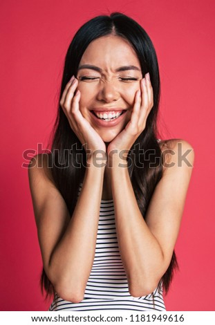 Happy and excited beautiful young asian woman portrait isolated on pink background. People emotions concept