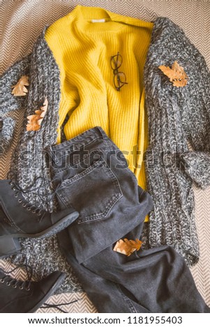 Autumn clothing outfit with sweaters, jeans and boots, top view of fall/winter season outfit idea