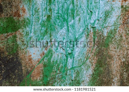 Green and white painted plate. Weathered texture. An old metal vertical surface with strips of rust and scratches. A picture from a close distance. Background for design, art and creativity.