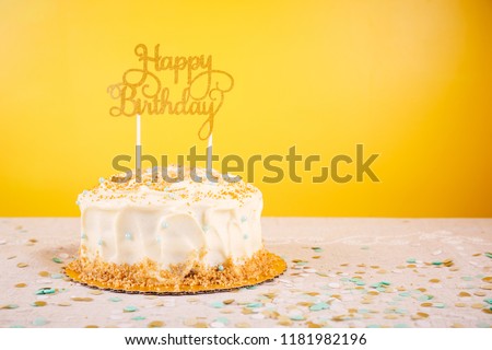 Birthday cake with golden topper. Birthday party celebration concept. Horizontal, bold yellow background