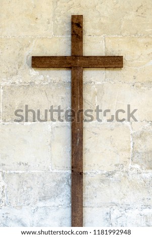 Old wooden cross on stone wall