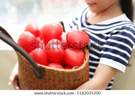 The red hearts is full in the wooden basket on the holding by happiness girl as the sharing concept