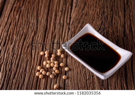 Soy Sauce with soy bean on wooden background