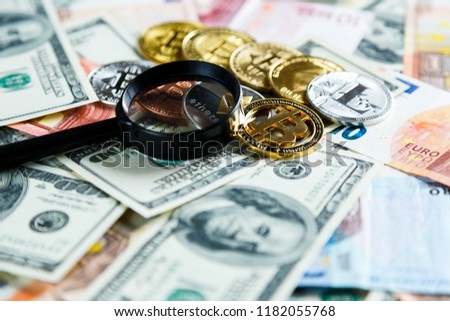  Bitcoins through magnifying glass on the real money background. Investment, risk, business strategy