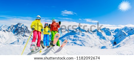 Happy family enjoying winter vacations in mountains. Ski, Sun, Snow and fun. Royalty-Free Stock Photo #1182092674
