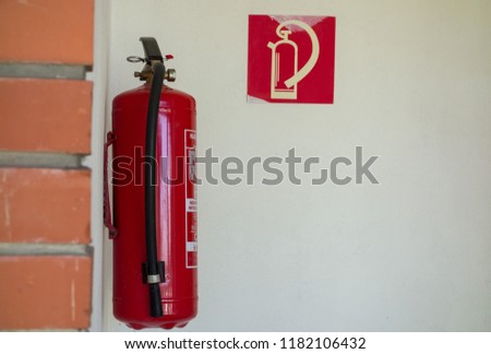 the fire extinguisher is suspended on the wall