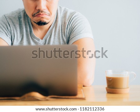 Serious and boring face of asian man work on laptop.