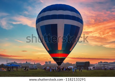 The balloon against the background of the silhouettes of the medieval castle in Lutsk, the cathedral and the trees at sunset.