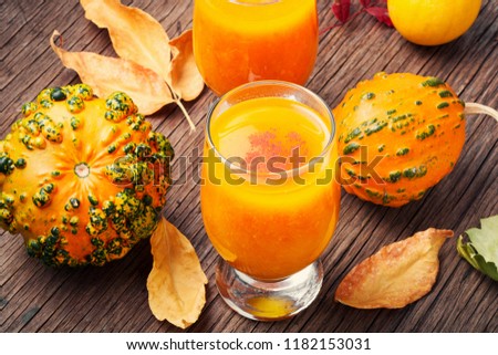 Pumpkin smoothie in a glass on vintage table.Autumn drink.