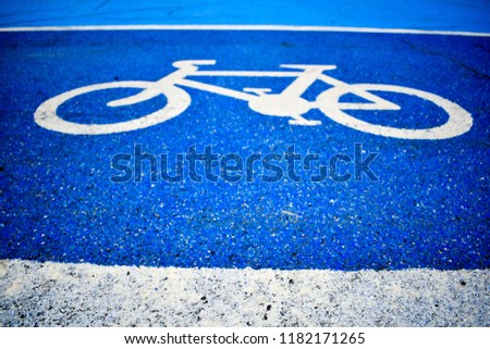 Bicycle lane signs on the bicycle way with blue colored asphalt