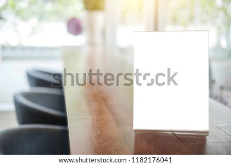 Mock up blank menu frame on table in coffee shop stand for your text of display your product.