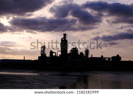 The silhouette of factory on the water