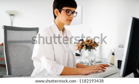 Charming female doctor typing on a keyboard