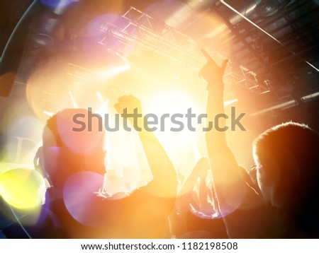 Concert lights over a crowd clapping