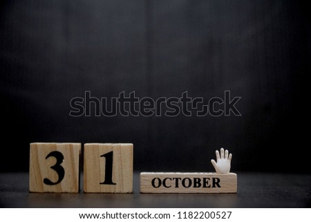 31 October. Dark tone of Wood block and little hand on black background. Holiday season. Halloween party. Can be use for advertising, banner, brochure, web. Free space for text.