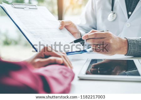 Doctors and patients sit and talk. At the table near the window in the hospital. Royalty-Free Stock Photo #1182217003