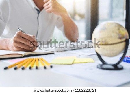 Businessman working writing making note business plan and graphic designer with computer in office.
