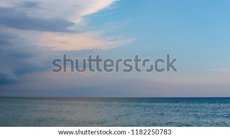Beautiful seascape, green and turquoise tones and shades on flat sea water surface, blue sky grey pink clouds before storm at sunset evening time. Natural colorful pattern background, widescreen frame
