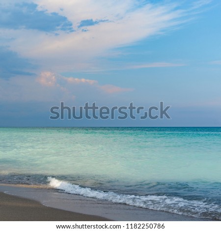 Beautiful seascape, green and turquoise tones and shades on flat sea water surface, blue sky and grey pink clouds before storm at sunset evening time. Natural colorful pattern background, square frame