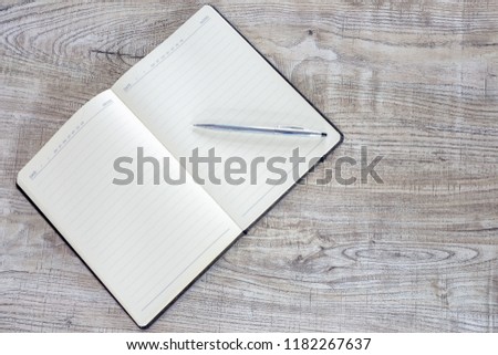 Note book and pen on wooden table 