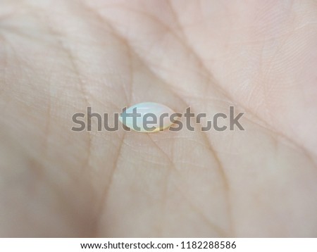 gemstone natural cabochon opal marquise shape on soft skin background with selective focus.