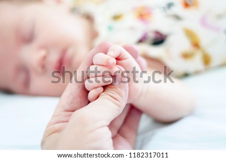 Sweet adorable newborn baby sleeping and holding a finger of her father with her tiny fingers. Child sleep, cute infant asleep.  Baby photo, newborn photoshoot photography.