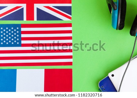 Learn english -  notepad, headphones, USA, British, Spanish and French flags on bright background.