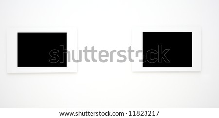 Two empty frames on white wall in museum